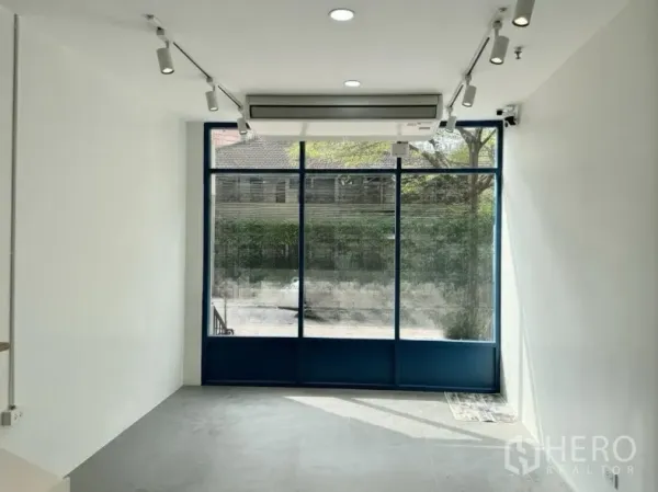 Retail Space for rent - Front room with floor-to-ceiling windows, split-type air conditioner, and ceiling spotlights.
