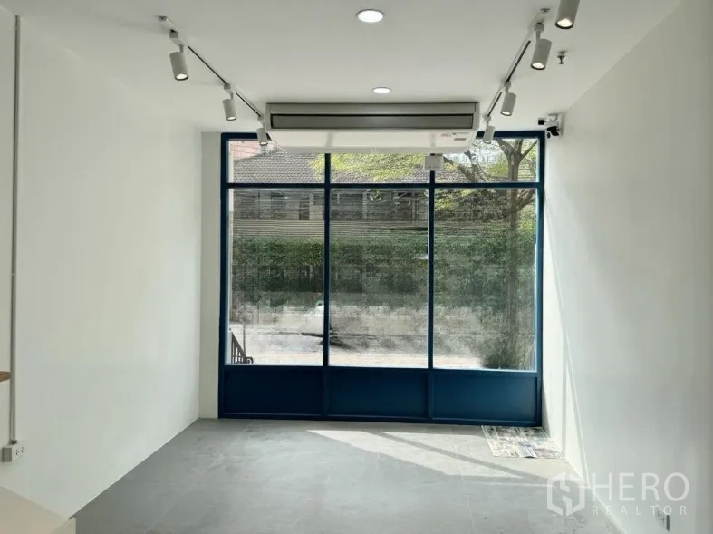 Retail Space for rent - Front room with floor-to-ceiling windows, split-type air conditioner, and ceiling spotlights.