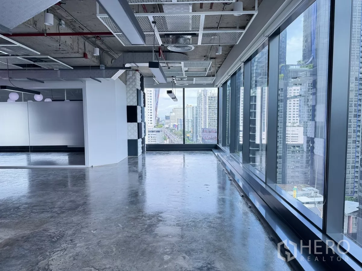 Office Space for rent in Din Daeng, Bangkok - Open-plan office with floor-to-ceiling windows, polished concrete floors, and a Bangkok skyline view.