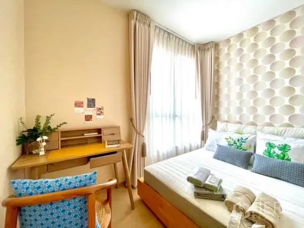 Condominium for rent or sale in Watthana, Bangkok - Cozy second bedroom with desk by a large window and textured geometric wallpaper.