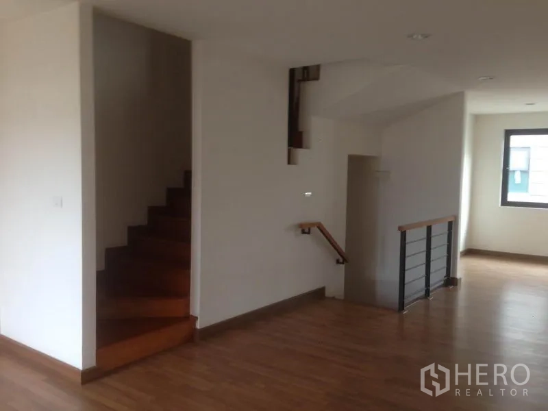 Home Office for rent in Bang Phli, Samut Prakan - Open-plan upper level featuring two staircases, wood floors and neutral walls.