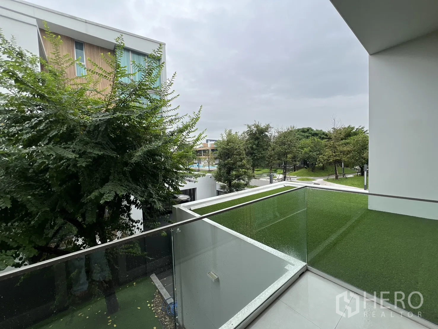 Detached House for rent in Saphan Sung, Bangkok - Balcony with glass railing overlooking the community park and greenery.