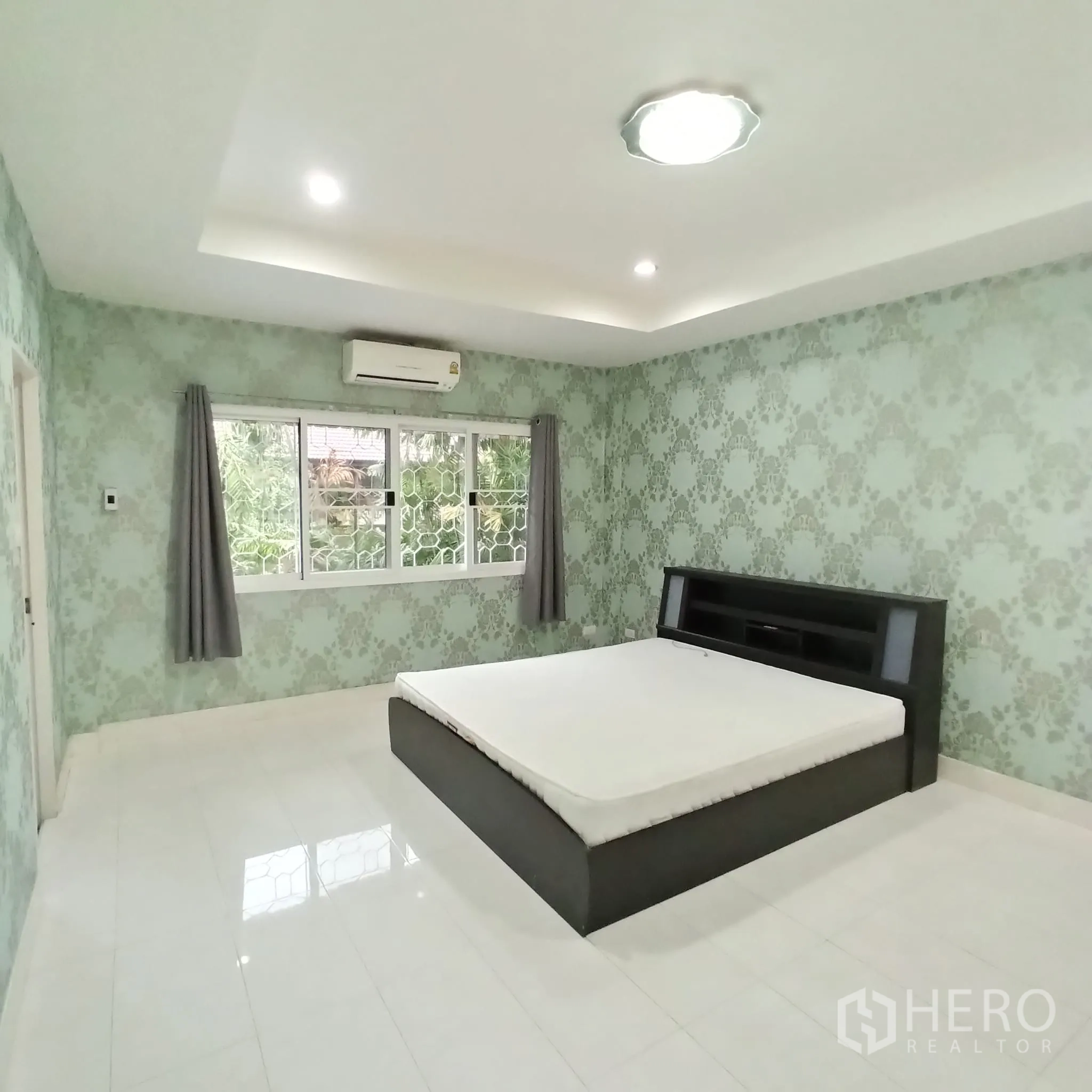 Townhouse for rent in Wang Thonglang, Bangkok - Bedroom with large windows, air conditioner and green wallpaper.