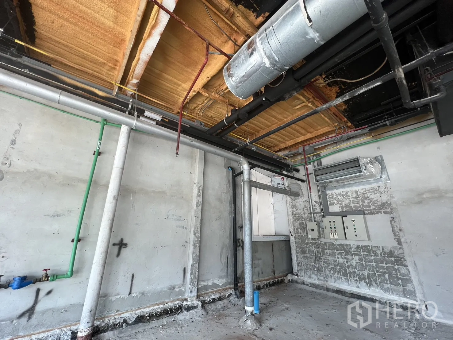 Retail Space for rent in Pathum Wan, Bangkok - Close-up of service wall showing plumbing lines, electrical panels, and insulated ceiling.