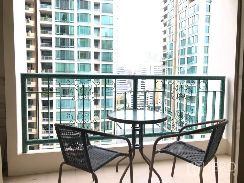 公寓 出租在Pathum Wan, Bangkok - 阳台小桌两椅，眺望奇隆区域高楼城市景观。