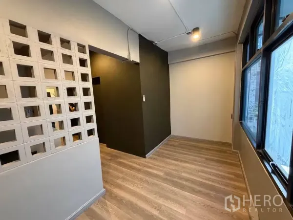 Home Office for rent in Watthana, Bangkok - Bright corner nook with breeze-block divider and large windows.