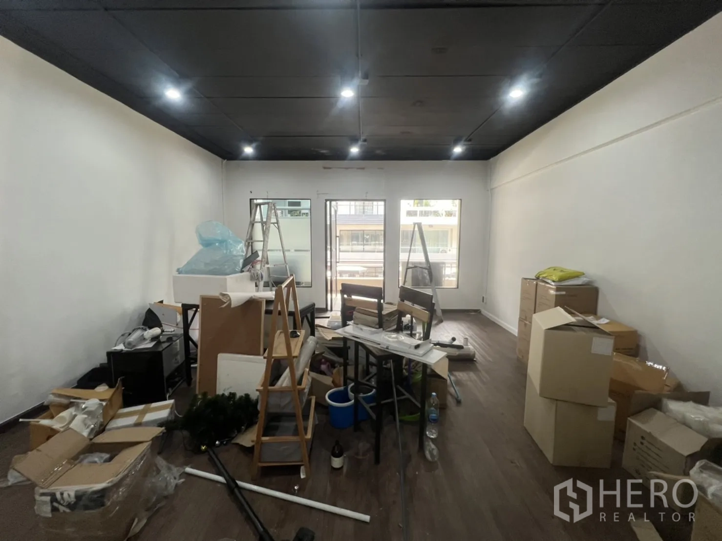 Retail Space for rent in Watthana, Bangkok - Spacious room mid-fit-out with boxes and equipment, recessed lights and a windowed frontage.