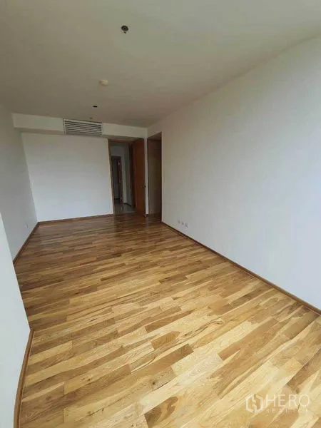 Condominium for rent or sale in Sathon, Bangkok - Bright room with polished hardwood flooring, white walls, and doorway to corridor.