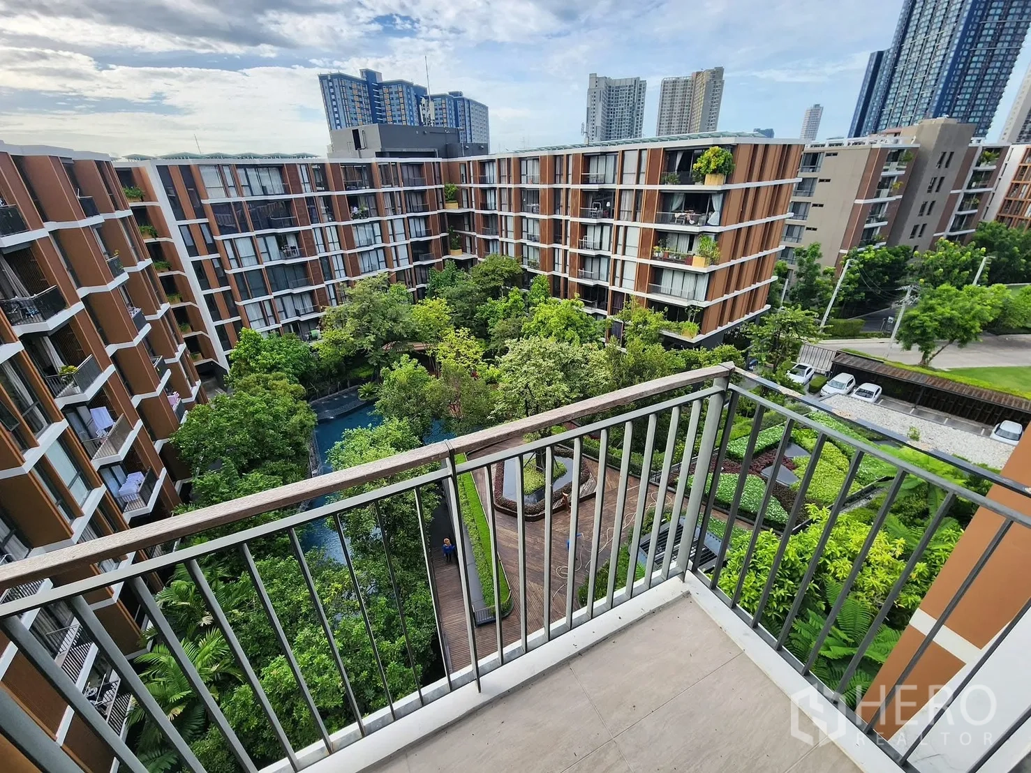 公寓 for rent in Watthana, Bangkok - 阳台远眺郁郁葱葱的中庭花园与低层住宅楼以及城市天际线。