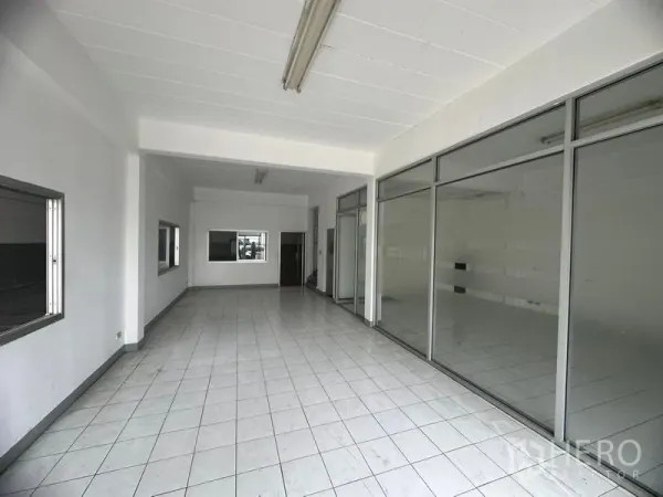 Factory for rent in Khlong Luang, Pathum Thani - Bright tiled reception or showroom with full-height glass walls and fluorescent lighting.