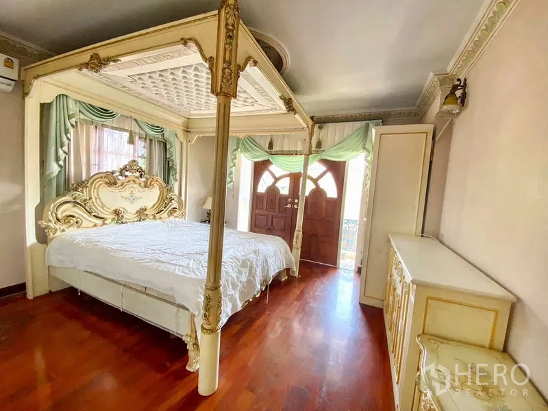 独立式住宅 出租或出售在Bang Khen, Bangkok - 卧室配四柱床，阳台门与复古柜体。