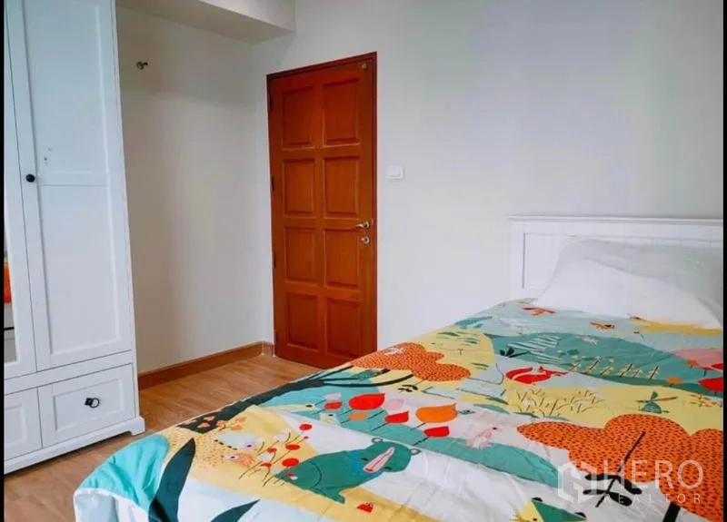 公寓 出售在Watthana, Bangkok - 温馨次卧，衣柜、木门与彩色床品。