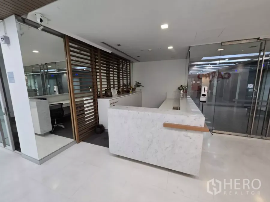 สำนักงาน ให้เช่าในWatthana, Bangkok - เคาน์เตอร์ต้อนรับหินอ่อนพร้อมประตูกระจกและฉากไม้ ในออฟฟิศกรุงเทพฯ