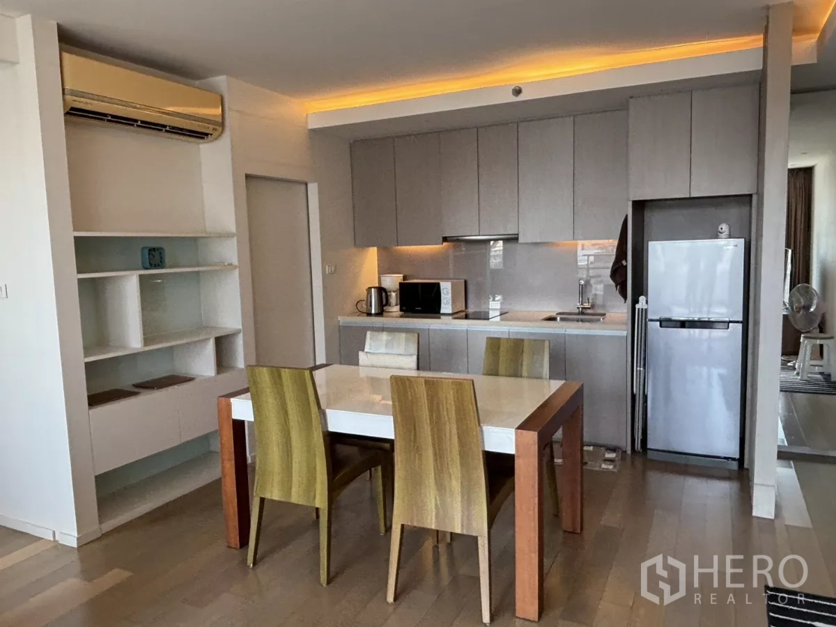 公寓 出售在Watthana, Bangkok - 开放式厨房，柜体齐全，配用餐桌与大冰箱。