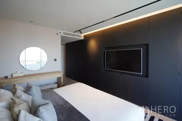 公寓 出租在Bang Phlat, Bangkok - 极简卧室，深色一体电视墙与浅色梳妆台相映成趣。
