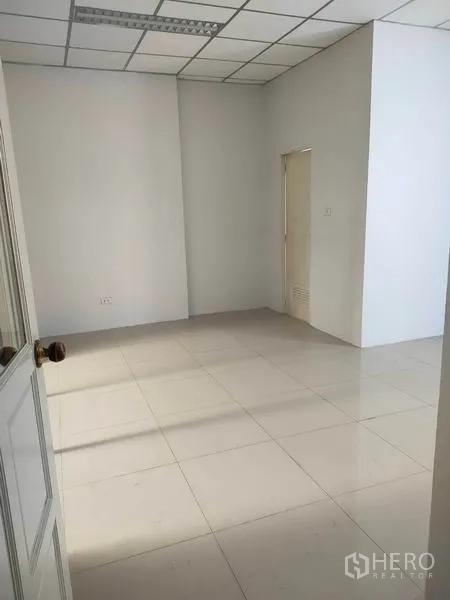 Factory for rent in Phra Nakhon Si Ayutthaya - Empty tiled office room with white walls and dropped ceiling inside the factory.
