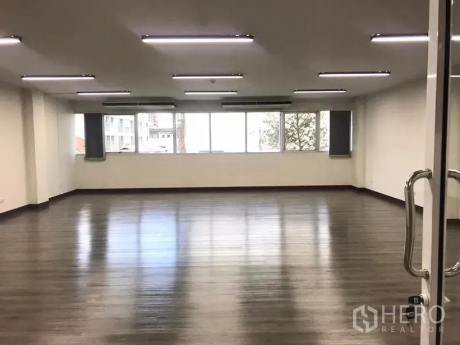 Office Space for rent in Bangkok Noi, Bangkok - Spacious open‑plan office with wood‑look floors, LED ceiling lights, and wide windows.