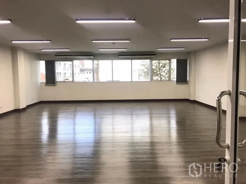 Office Space for rent in Bangkok Noi, Bangkok - Spacious open‑plan office with wood‑look floors, LED ceiling lights, and wide windows.