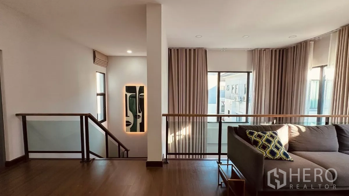 บ้าน ให้เช่าในBang Phli, Samut Prakan - เลานจ์ชั้นบน โซฟา L‑shape ระเบียงกระจกและหน้าต่างสูง