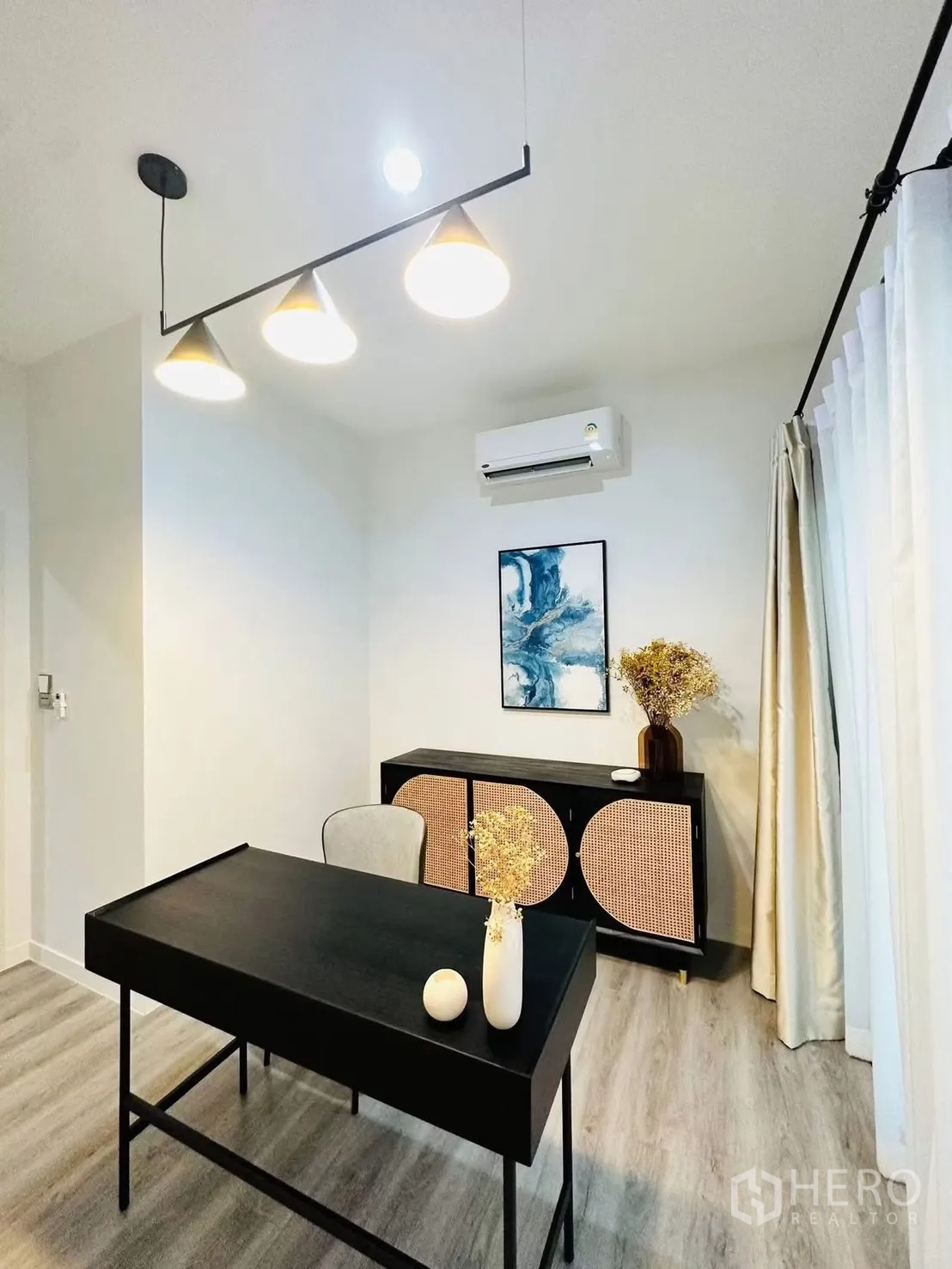 联排别墅 for rent in Suan Luang, Bangkok - 安静书房，黑色书桌、收纳柜与现代吊灯。