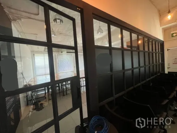 สำนักงาน ให้เช่าในKhlong Toei, Bangkok - มุมมองทางเดินที่มีผนังกระจกกรอบดำ เชื่อมสู่ห้องประชุมหรือโซนทำงาน