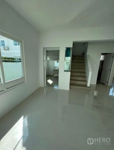 独立式住宅 出租在Min Buri, Bangkok - 一层开放式布局，起居区、厨房入口与楼梯相连。