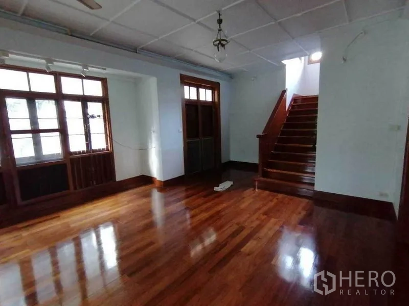 独立式住宅 出租在Pathum Wan, Bangkok - 起居区，大窗与通往二层的楼梯