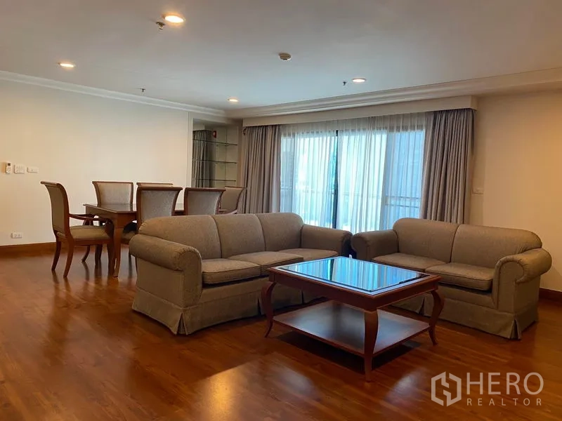 公寓 出租在Watthana, Bangkok - 宽敞客厅，两张沙发与茶几，连接阳台与用餐区。