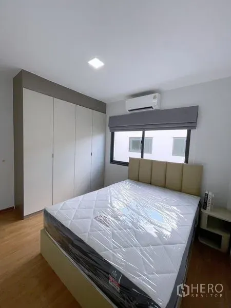 Townhouse for rent in Bang Phli, Samut Prakan - Cozy bedroom with window, padded headboard and floor-to-ceiling wardrobe.