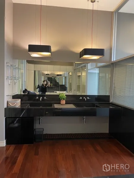 Townhouse for rent or sale in Chatuchak, Bangkok - Double-sink vanity with black countertop, large mirror and pendant lights.