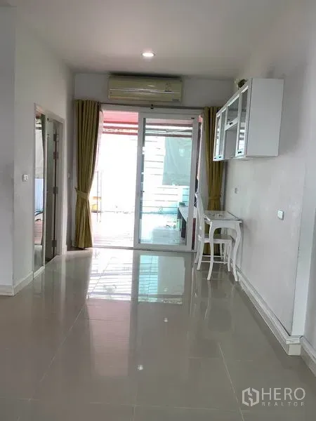 联排别墅 出租或出售在Wang Thonglang, Bangkok - 开放式起居区，装有空调，推拉门通往半户外空间，墙柜与白色书桌一体。