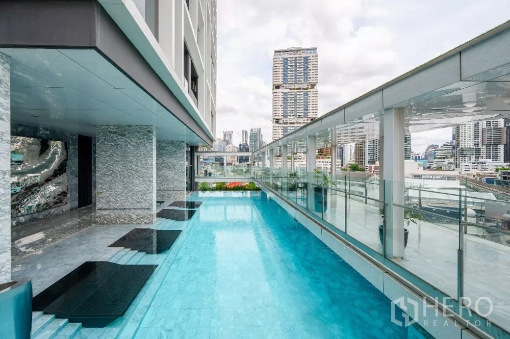 Condominium for rent or sale in Khlong Toei, Bangkok - Elevated swimming pool with city views and deck loungers at the condominium.