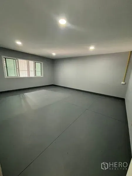 Warehouse for rent in Mueang Pathum Thani, Pathum Thani - Bright office room inside the warehouse with windows and recessed ceiling lights over a grey floor.