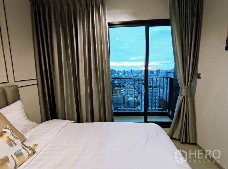 คอนโด ให้เช่าในRatchathewi, Bangkok - ห้องนอนเปิดสู่ระเบียงขนาดเล็ก ชมวิวสกายไลน์ยามโพล้เพล้