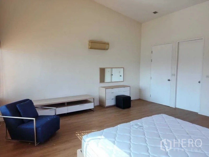 公寓 出租在Phaya Thai, Bangkok - 宽敞卧室，蓝色休闲椅、抽屉柜与双扇门。