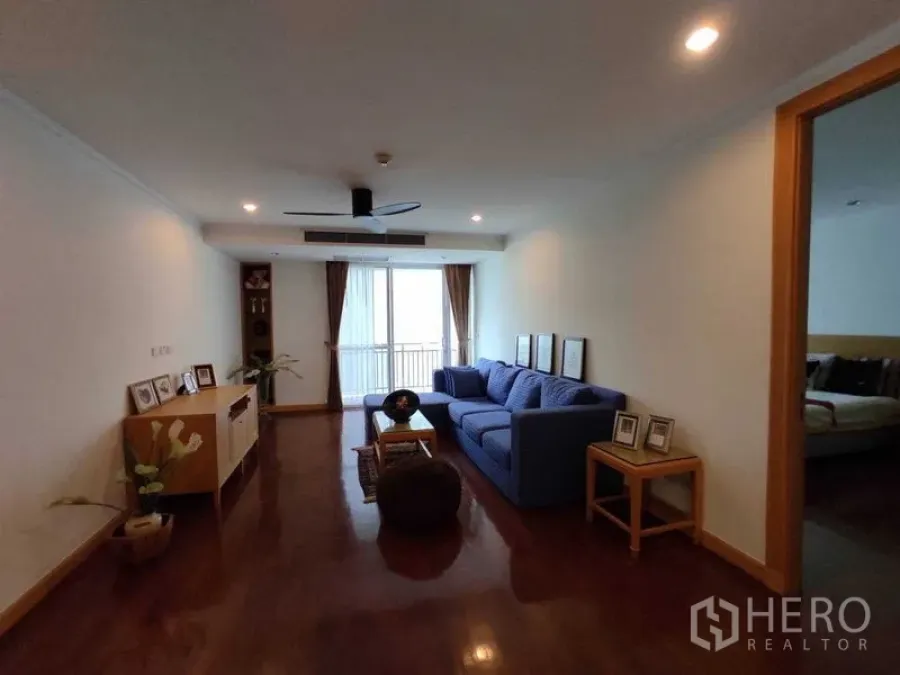 公寓 出租在Khlong Toei, Bangkok - 家庭客厅，蓝色沙发、筒灯照明并通向小阳台。