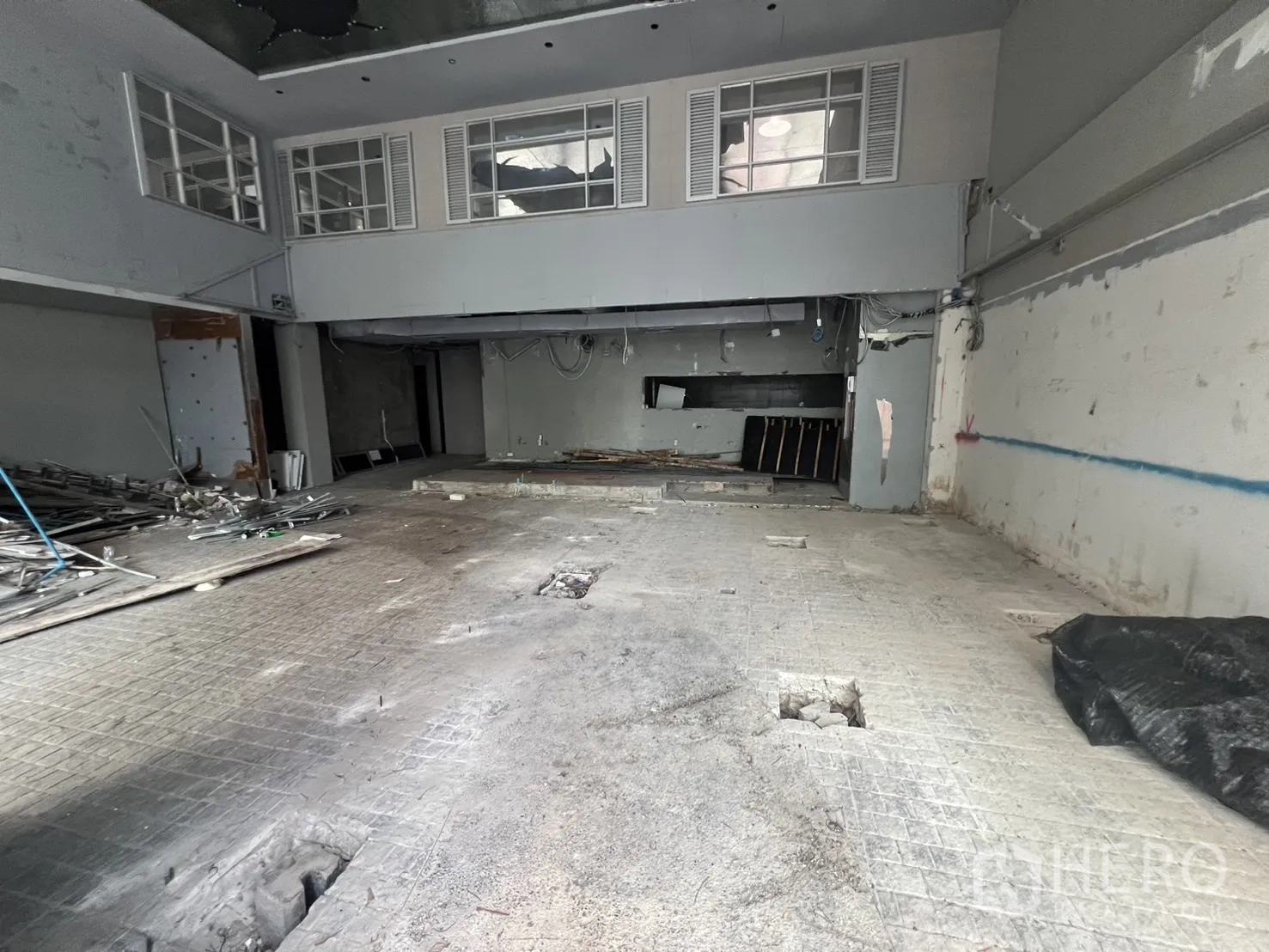 Retail Space for rent in Watthana, Bangkok - Raw interior shell with high ceiling, partial mezzanine, and open floor.