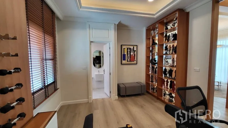 Detached House for rent or sale in Saphan Sung, Bangkok - Multipurpose room or home office with built-in display shelves, wine rack, and wood blinds.