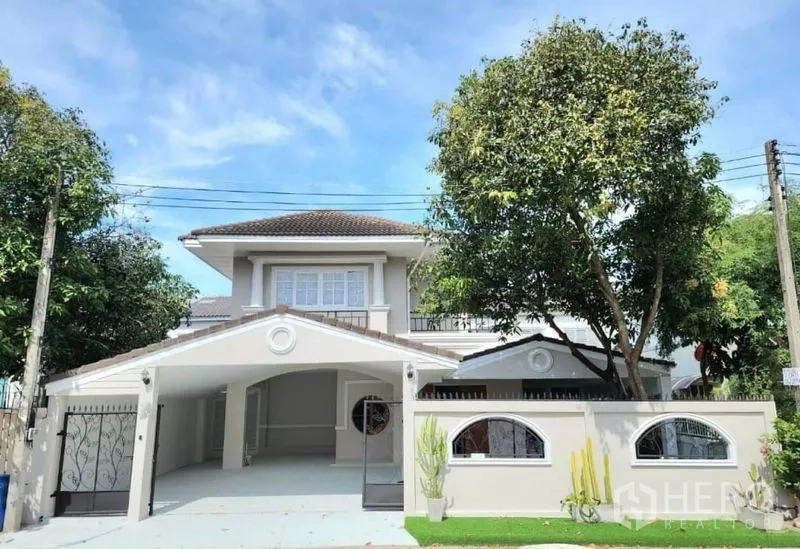 Detached House for rent in Lam Luk Ka, Pathum Thani - Two-storey detached house facade with gated driveway and mature trees.