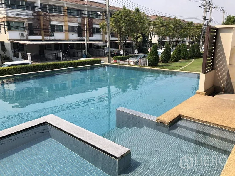Townhouse for rent in Bang Kapi, Bangkok - Resident swimming pool with stepped entry and landscaped communal area.