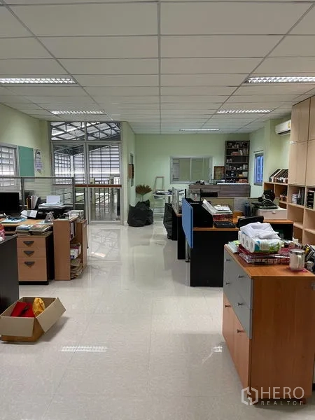 Warehouse for rent in Khan Na Yao, Bangkok - Open-plan office level with desks, storage units, and air-conditioning above the warehouse.