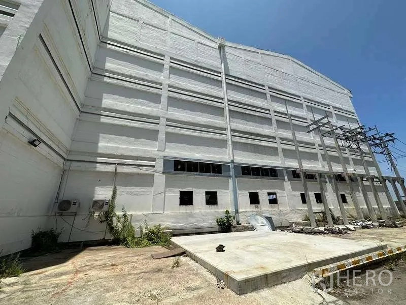 工厂 出租在Mueang Samut Prakan, Samut Prakan - 厂房外墙旁的混凝土作业区与平台和管线设施。