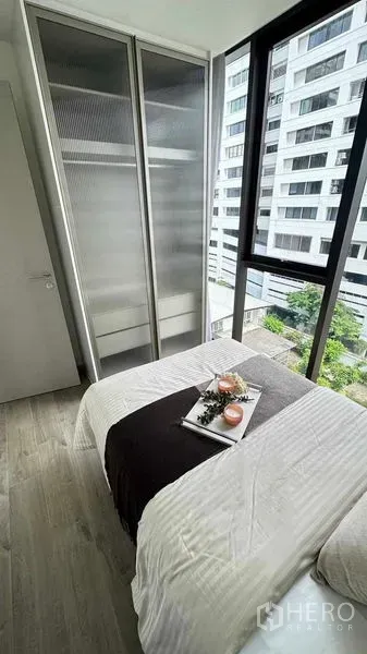 คอนโด ให้เช่าในWatthana, Bangkok - ห้องนอนขนาดกะทัดรัดพร้อมหน้าต่างบานใหญ่ ชุดเครื่องนอนสีขาว และตู้เสื้อผ้าบานเลื่อนกระจกฝ้า วิวเมือง