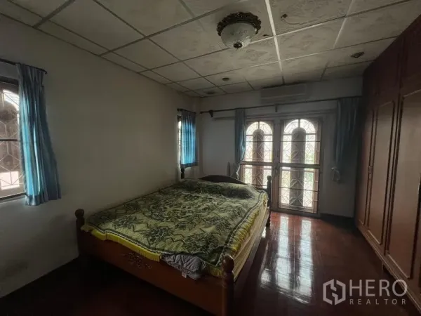 独立式住宅 出售在Phra Khanong, Bangkok - 卧室配木地板、拱形阳台门、窗户与内置衣柜。