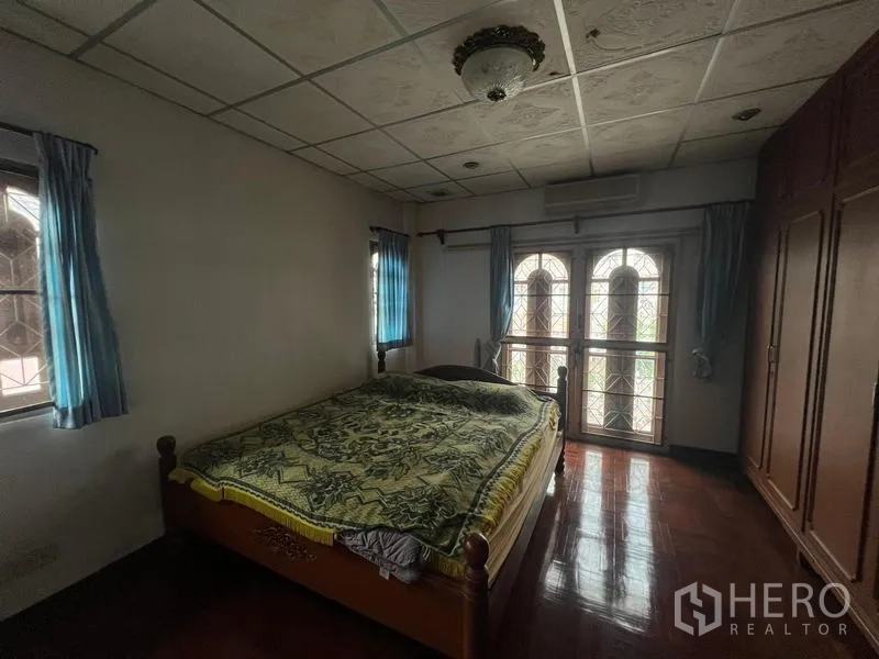 独立式住宅 出售在Phra Khanong, Bangkok - 卧室配木地板、拱形阳台门、窗户与内置衣柜。