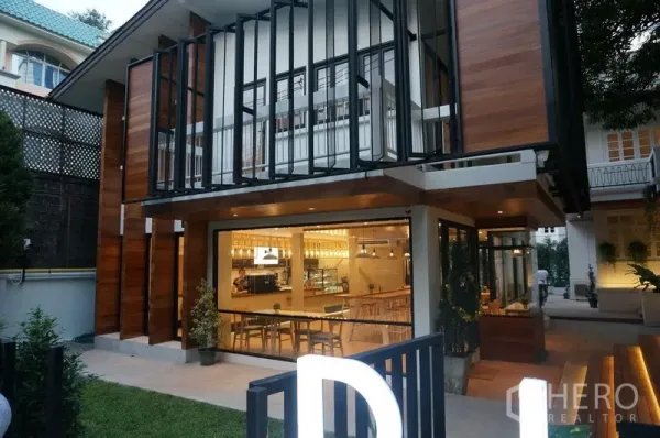 Retail Space for rent in Bang Rak, Bangkok - Evening view of a glass-front retail storefront with warm lighting, outdoor seating area and landscaped entry in Silom.