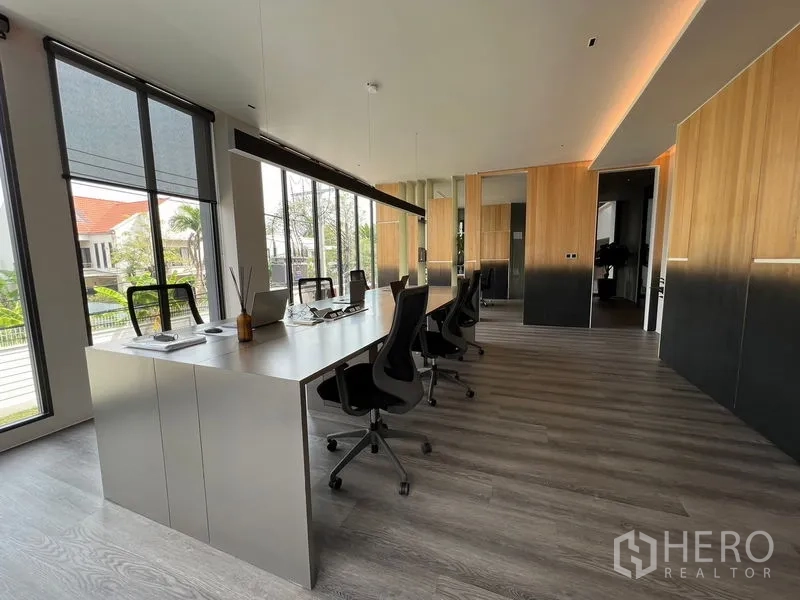 带办公室的家 出售在Prawet, Bangkok - 开放式办公区，长桌、人体工学椅与落地窗采光。
