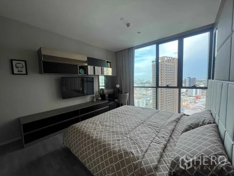 Condominium for rent in Khlong Toei, Bangkok - Master bedroom with full-height windows framing Bangkok skyline views.