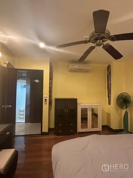 公寓 出售在Watthana, Bangkok - 卧室另一角度，见吊扇、空调、独立柜体与木地板。