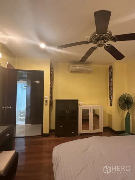 公寓 出售在Watthana, Bangkok - 卧室另一角度，见吊扇、空调、独立柜体与木地板。